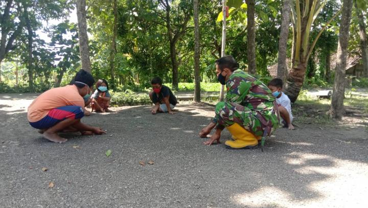 Manfaatkan Waktu, Anggota Satgas TMMD Bojonegoro Main Kelereng Bareng Anak-Anak